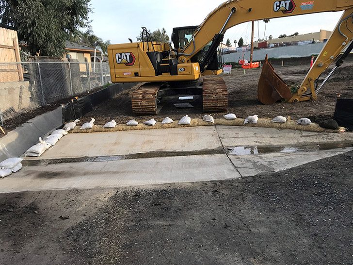 CAT excavator and sandbagged concrete at a Patriot General civil site